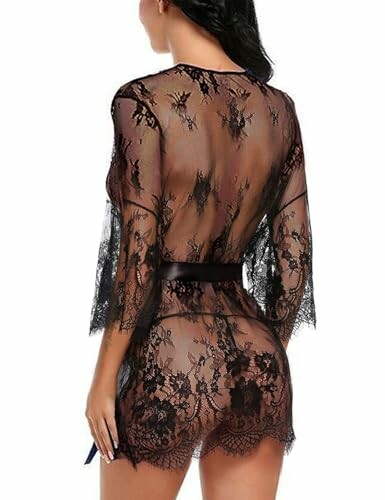 Mujer con bata de encaje negro transparente vista desde atrás.